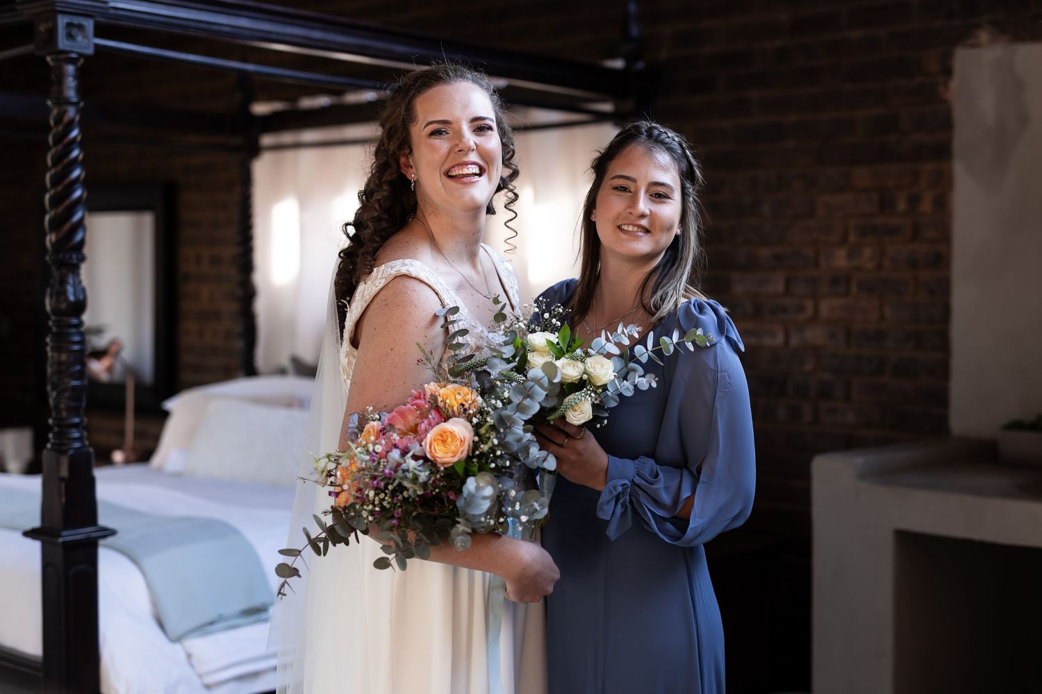 Two people share a joyful moment in a rustic indoor setting, one holding a colorful floral bouquet.