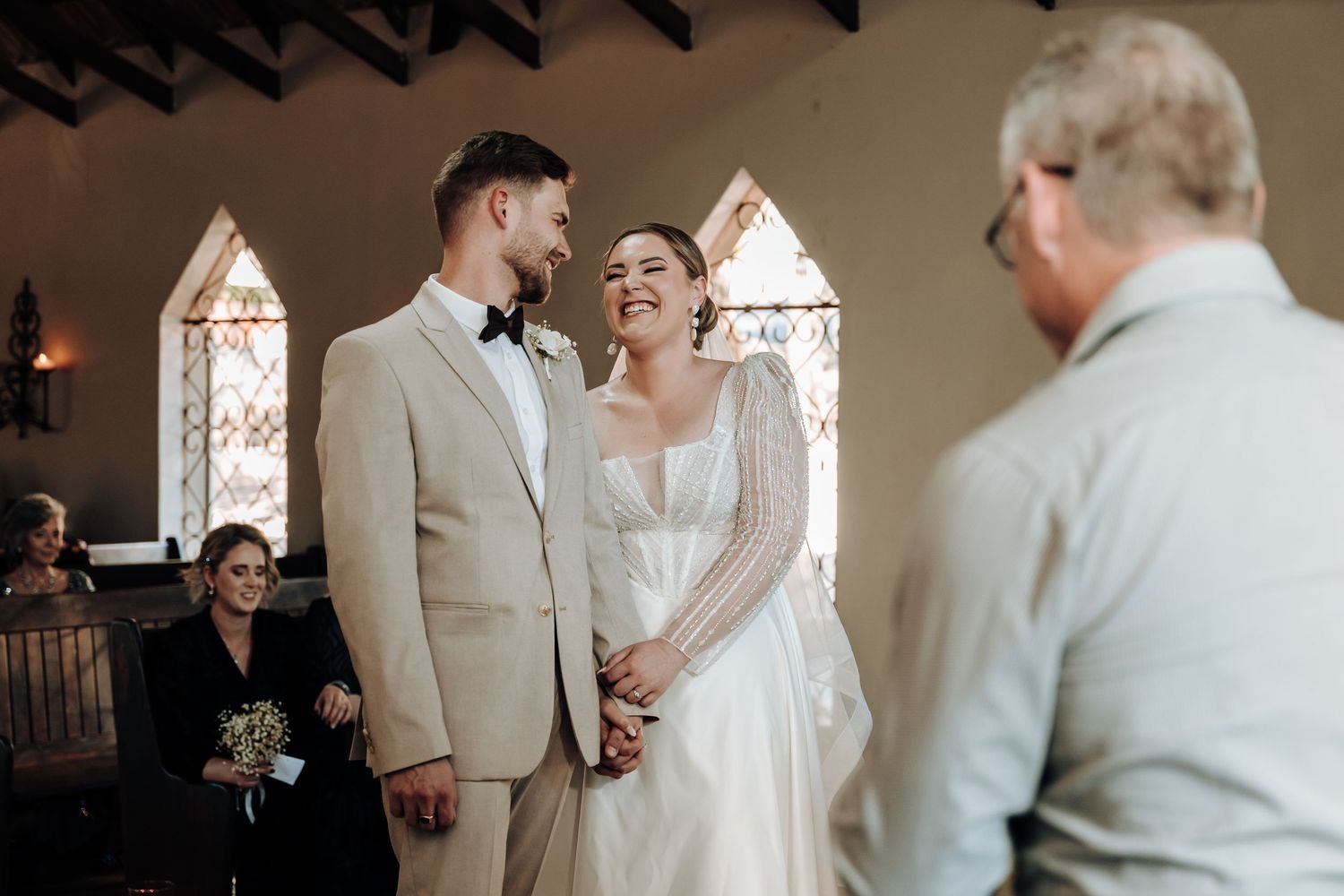 A couple shares a moment during their wedding ceremony as the officiant conducts the service.