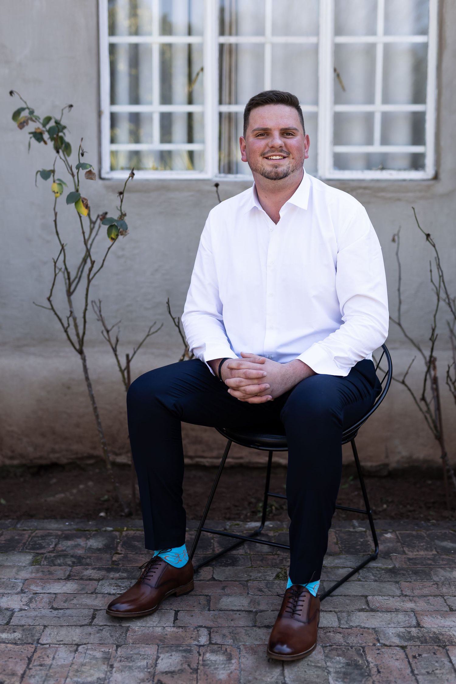 Series of four professional portraits showing someone seated outdoors in business attire against a building exterior.
