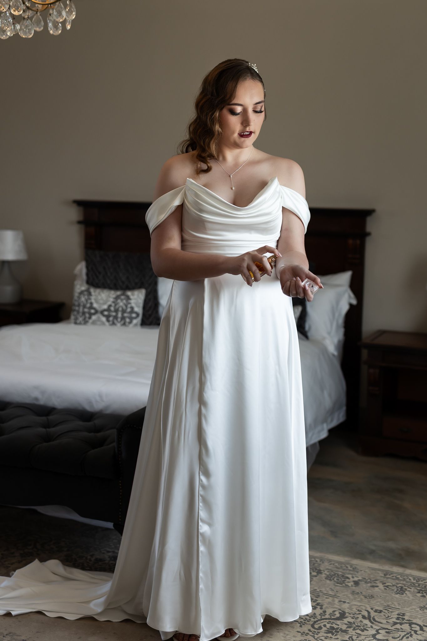 Full length view of flowing white wedding gown with off-shoulder detail.