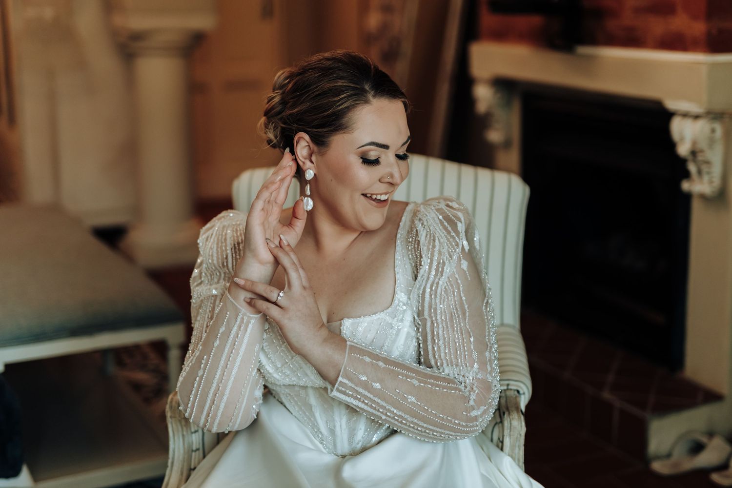 Dreamy bridal photo featuring sparkly long sleeves and delicate jewelry in romantic lighting.