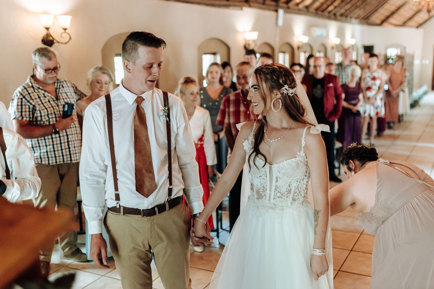 Couple exchanges vows during wedding ceremony in charming indoor venue with guests watching.