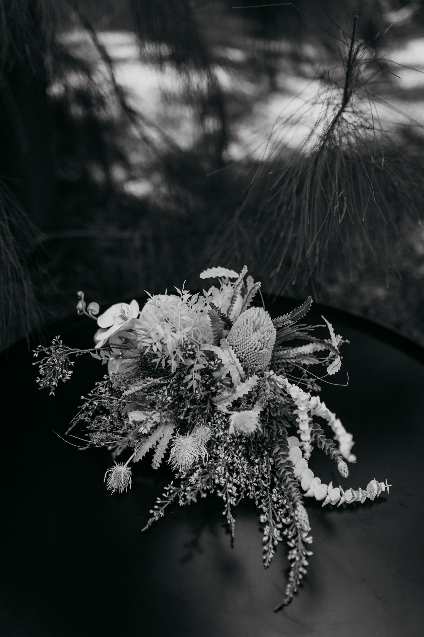 Black and white photo of an elegant dried flower wedding bouquet with cascading elements.