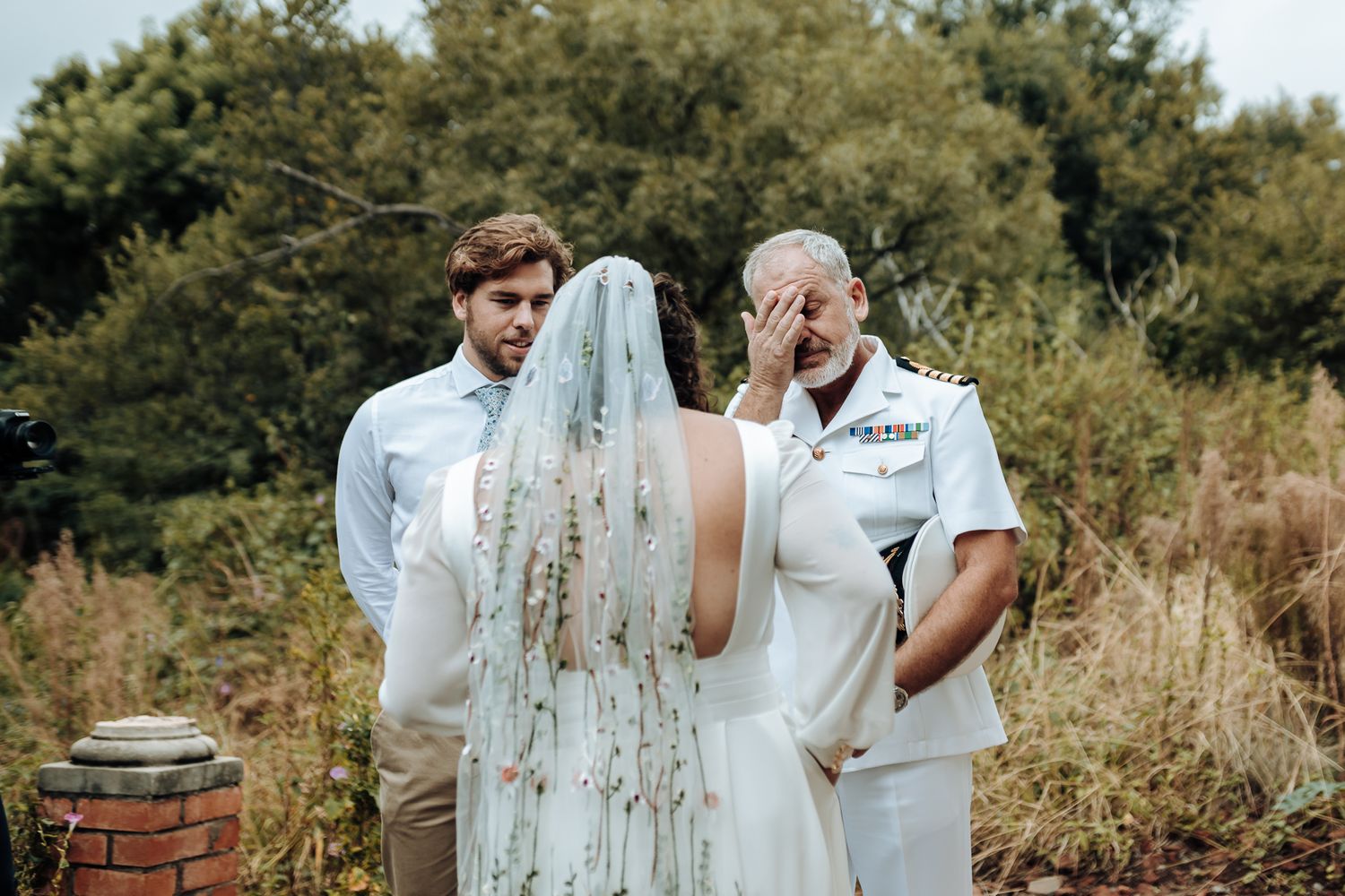 Emotional wedding ceremony moment in an outdoor garden setting.