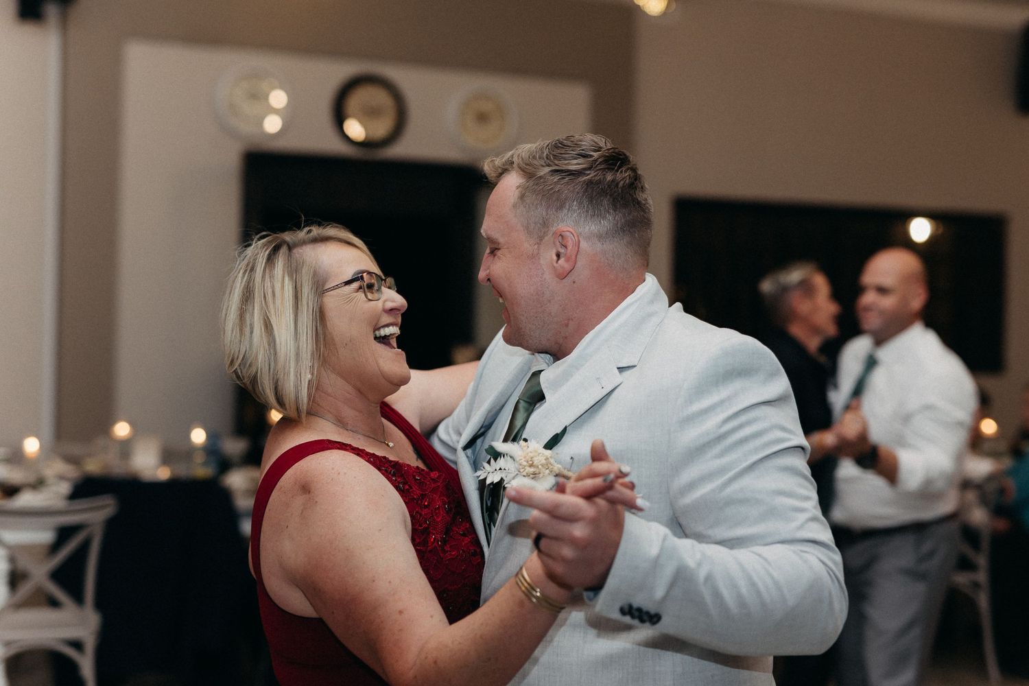 A joyful couple dancing and laughing together at a wedding reception.