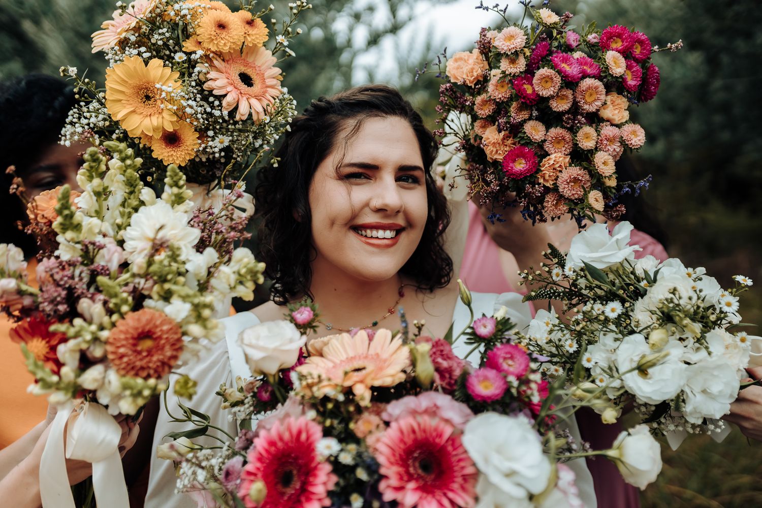 Close-up portrait surrounded by vibrant pink, peach and white floral bouquets.