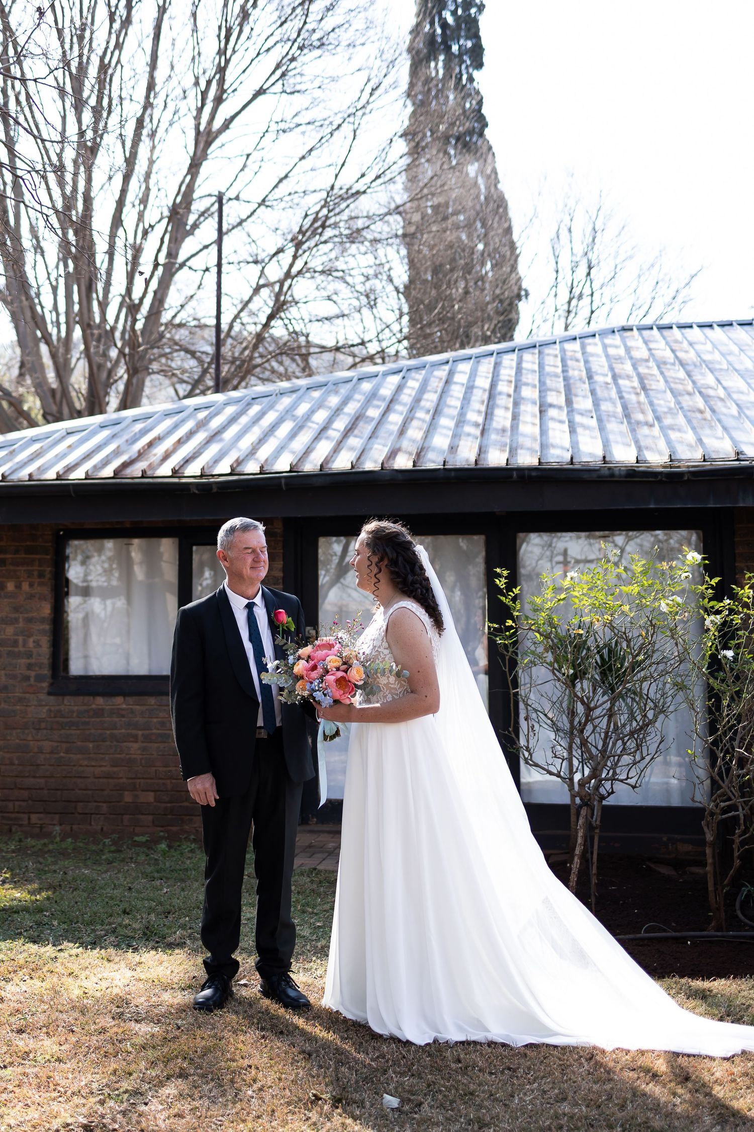 A series of wedding photos showing a first look moment between a bride and her escort on a bright sunny day.
