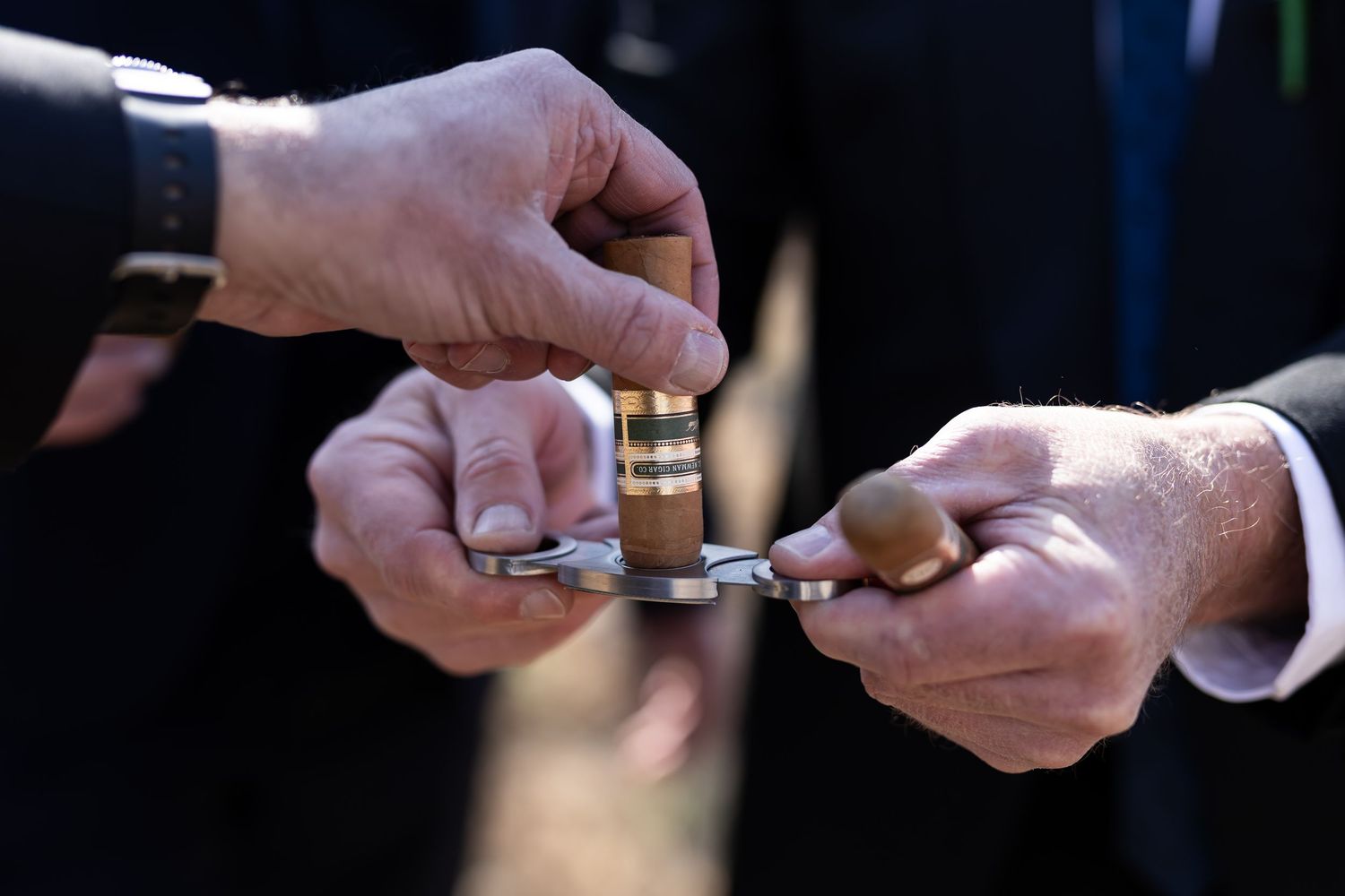 Two hands exchanging rings in a wedding ceremony, with one person holding a silver and gold wedding band.
