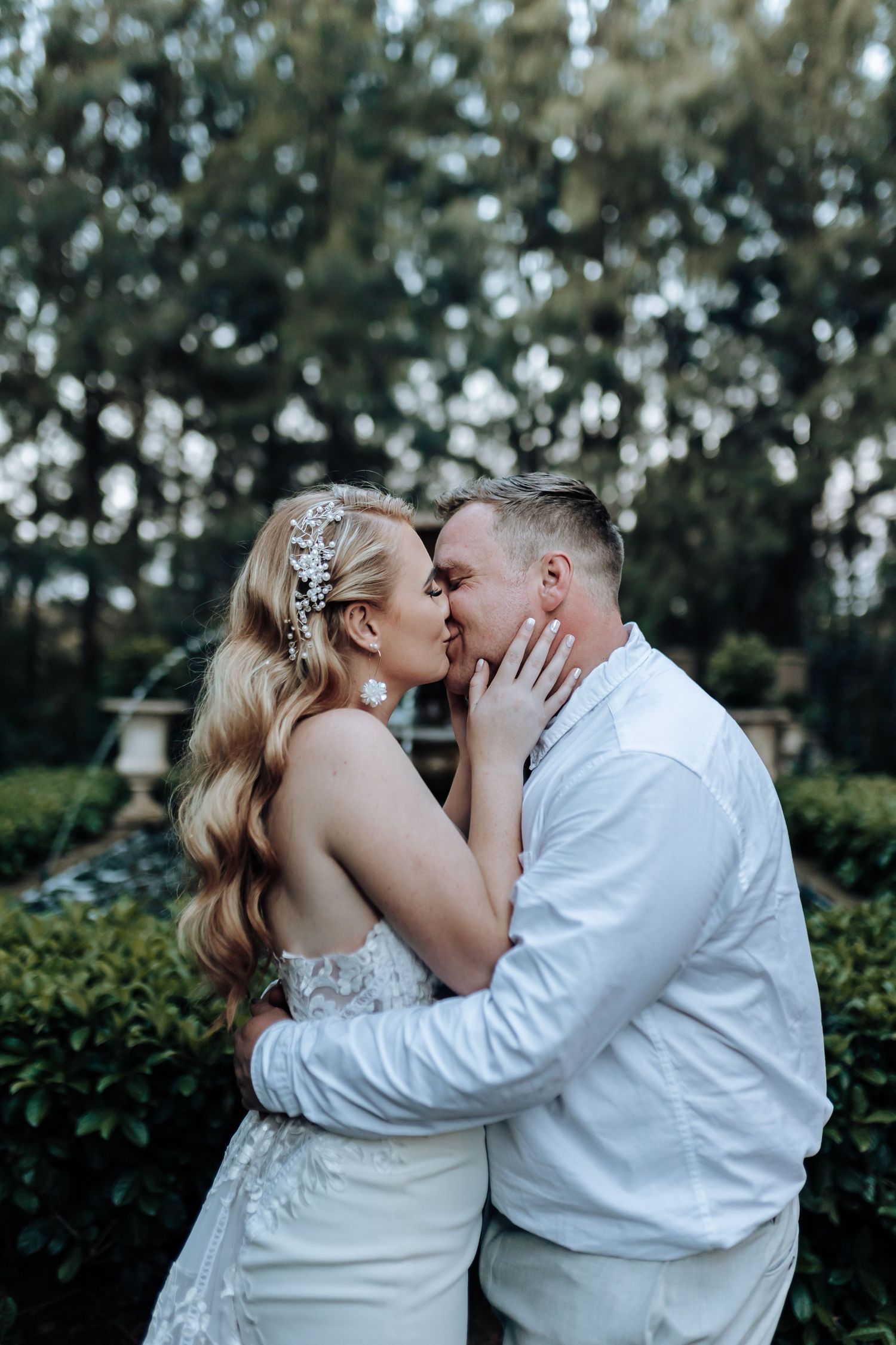 A tender moment shared between newlyweds in a garden setting.
