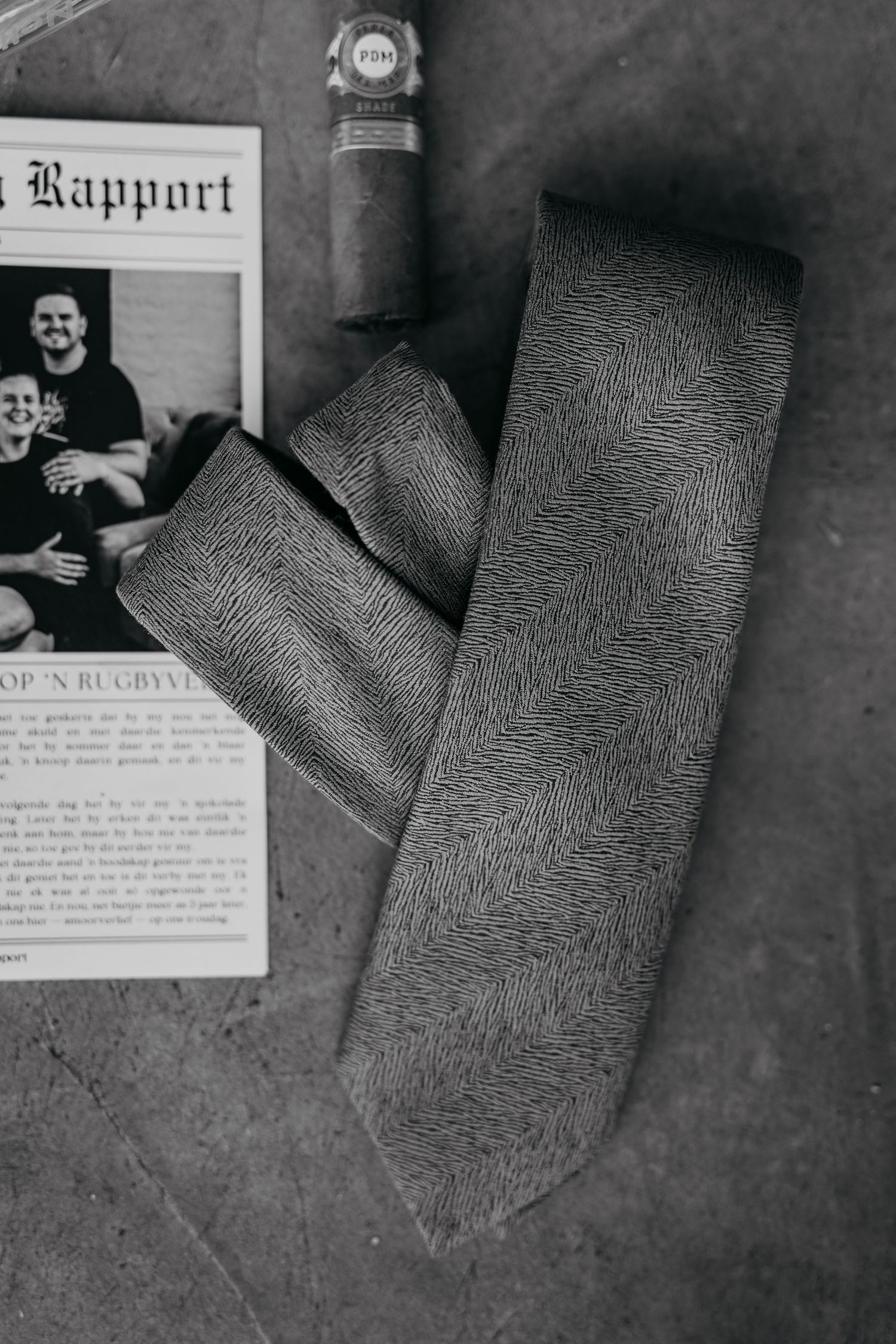 Black and white photos of documents and fingerprints laid out on a dark surface show forensic evidence materials.