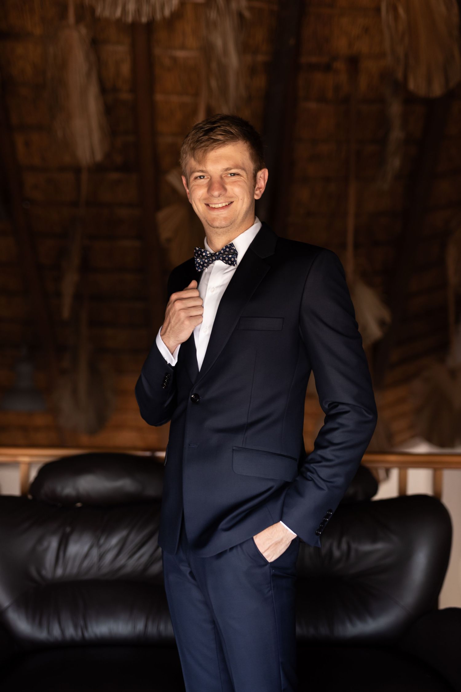 Elegant formal portrait featuring classic navy tuxedo with bow tie.