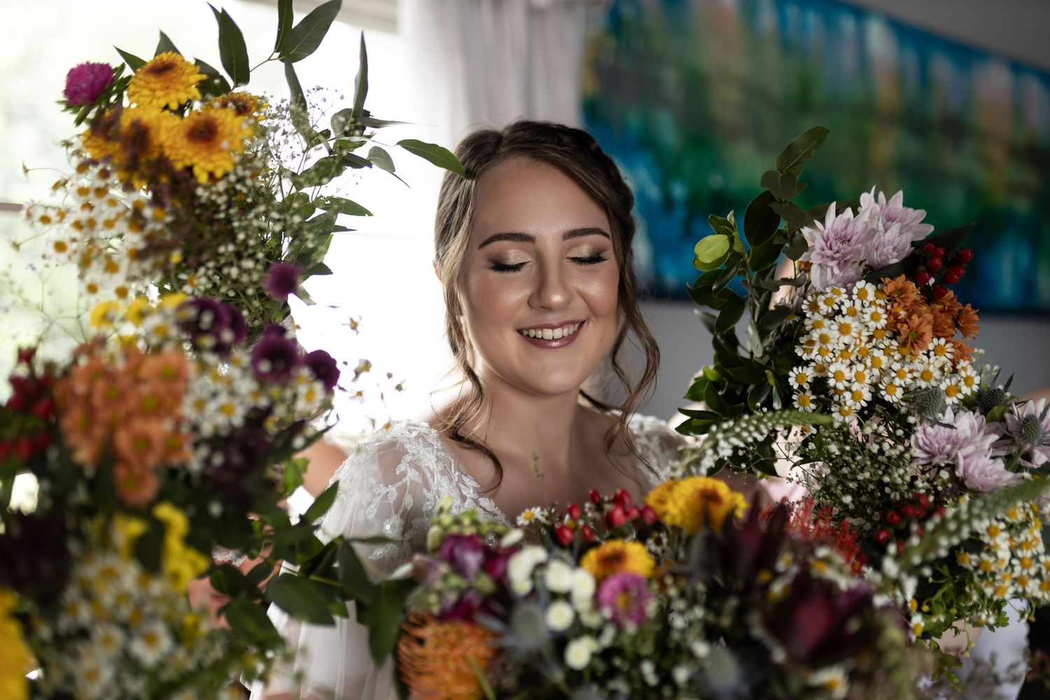 A dreamy bridal portrait surrounded by vibrant wildflowers and greenery.
