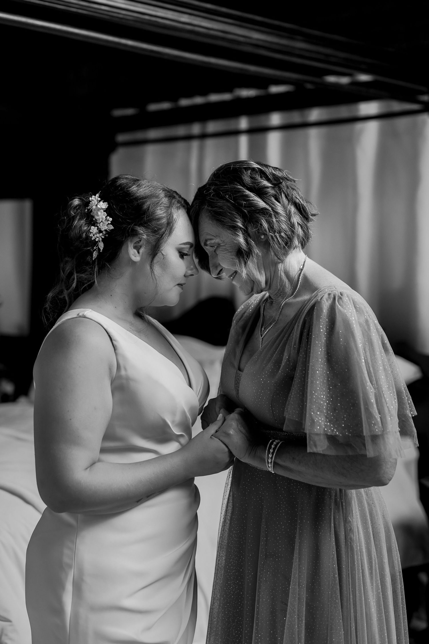 Intimate black and white moment between two people in formal attire.