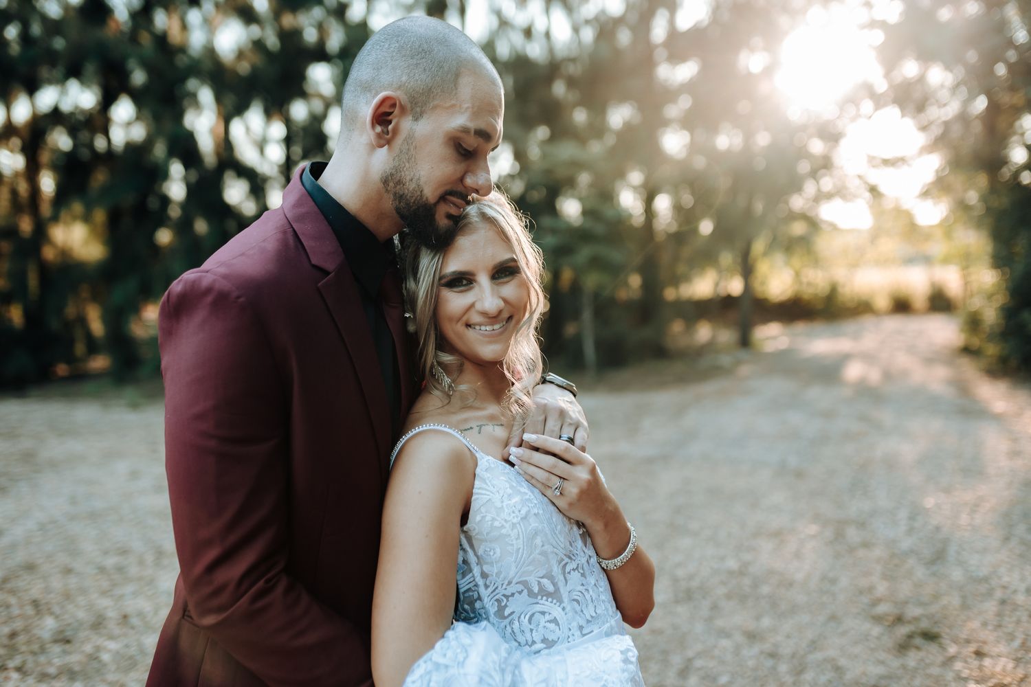 Intimate outdoor wedding portrait with sunset lighting and natural scenery.