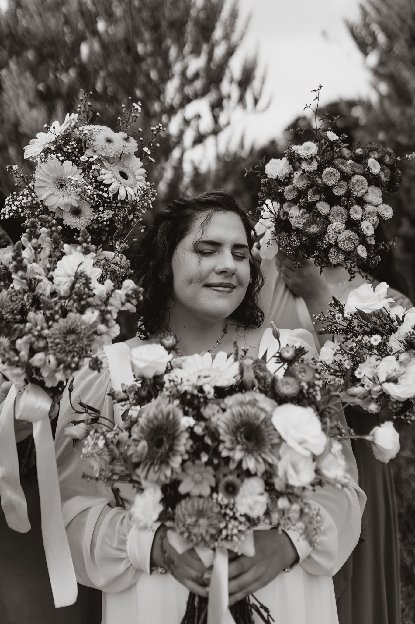 Black and white portrait surrounded by daisy and rose bouquets.