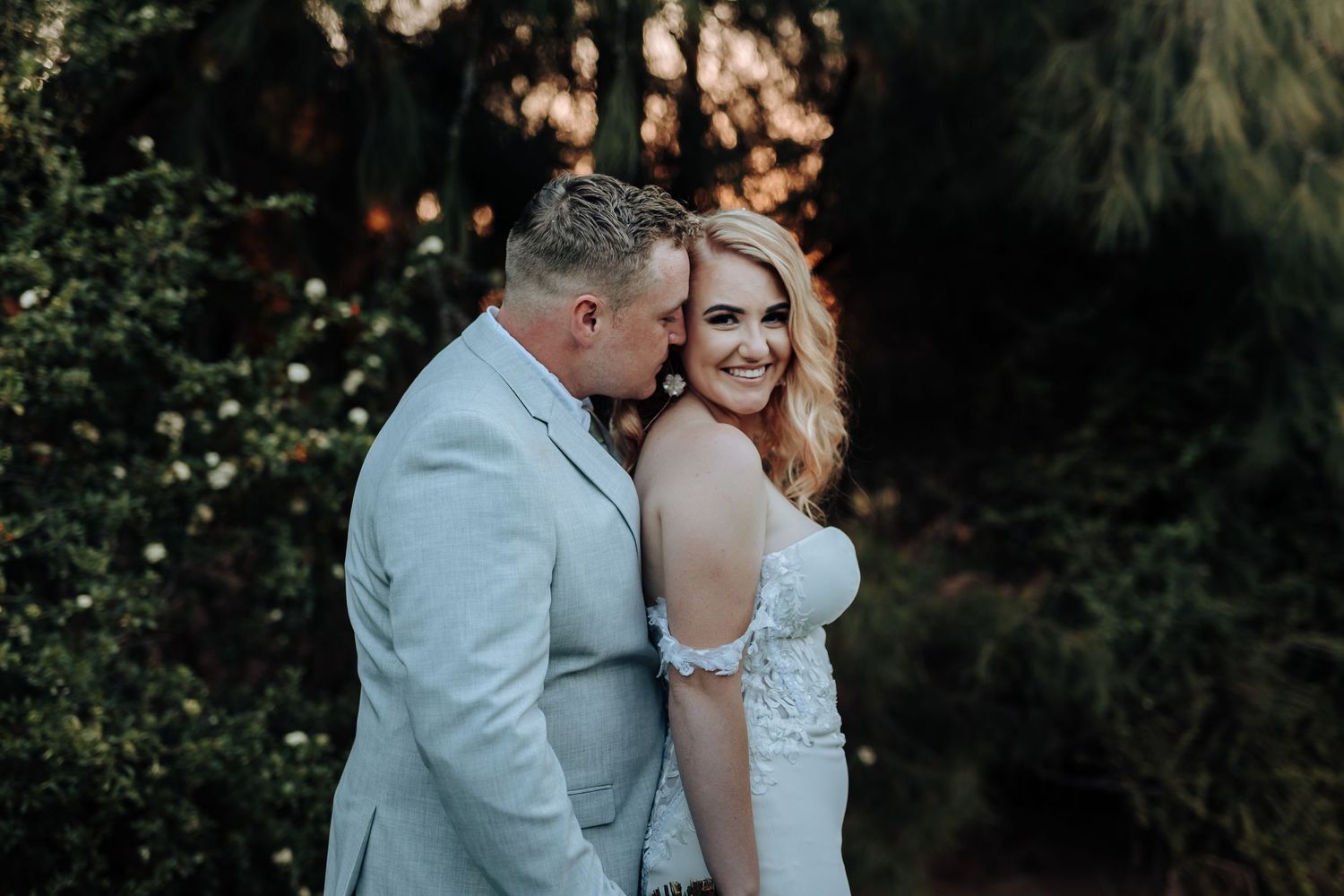 Romantic moment between couple during outdoor wedding photoshoot at dusk.