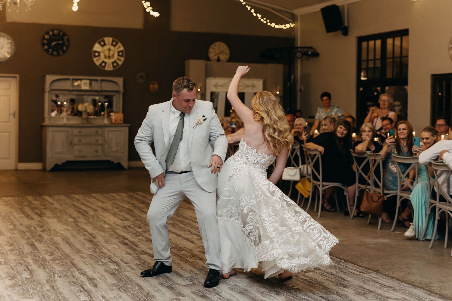 Energetic dance moves on display during wedding reception in rustic venue with hardwood floors.