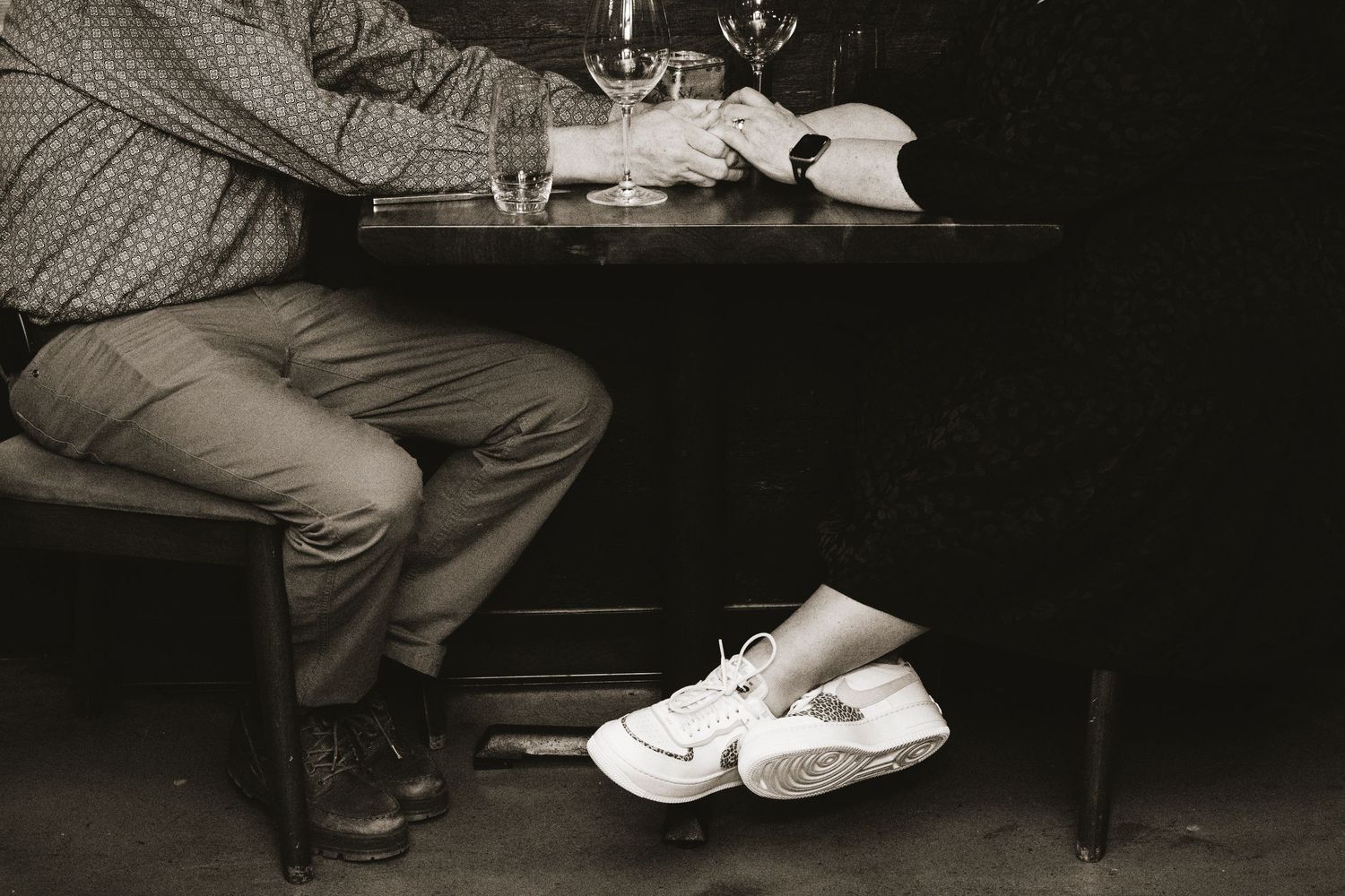 Black and white photograph of a couple sitting at a Nashville restaurant celebrating their 25th Wedding Anniversary.