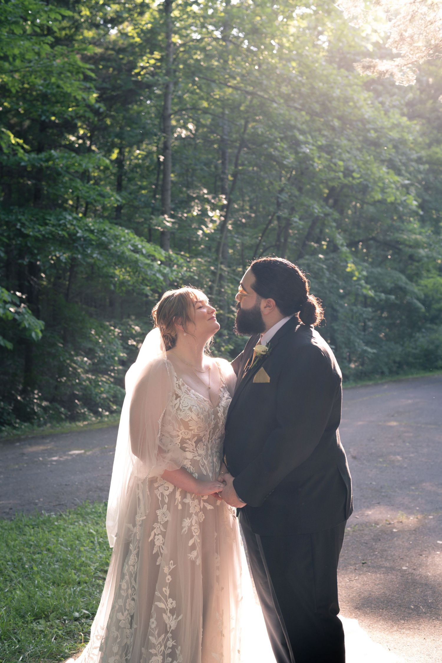 A tender moment between bride & groom after vows as the sunshine pours through the forest canopy; moments like these are timeless.