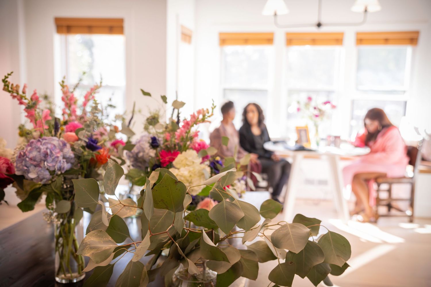 Bridal bouquets wait in their vases of water as family gathers and enjoys time together before the ceremony; another successful detail photo