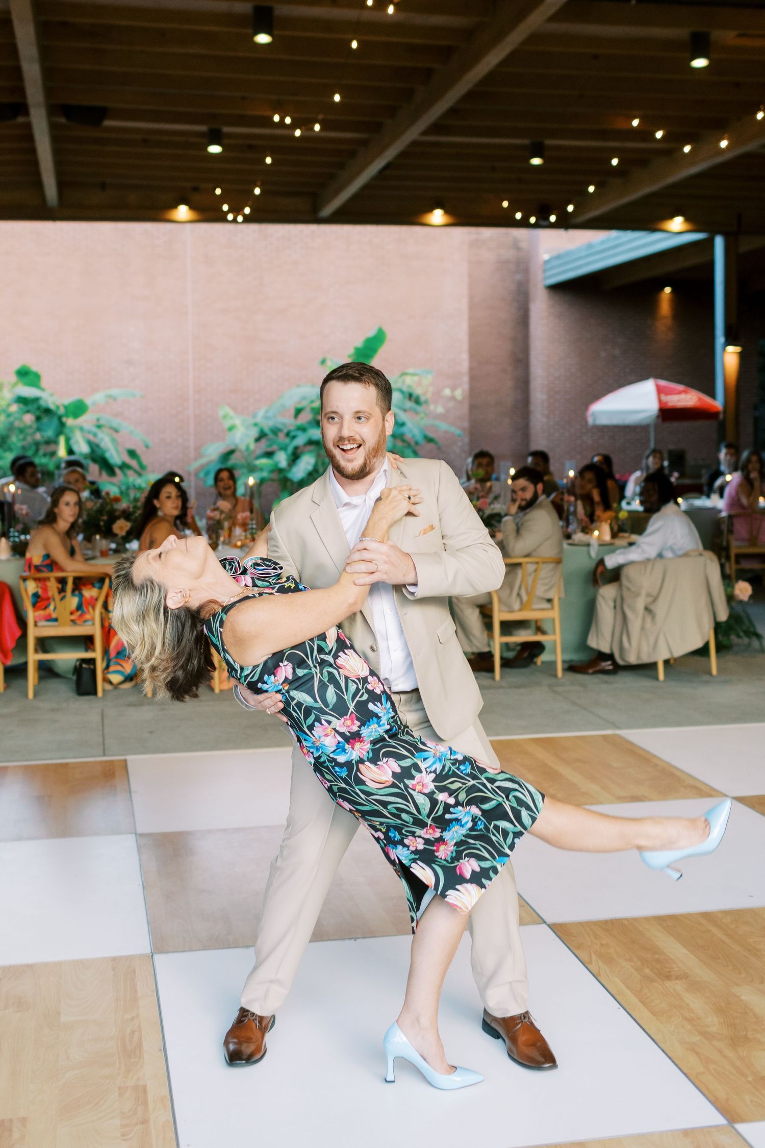 Dynamic wedding dance sequence showing fun dip move on reception dance floor.