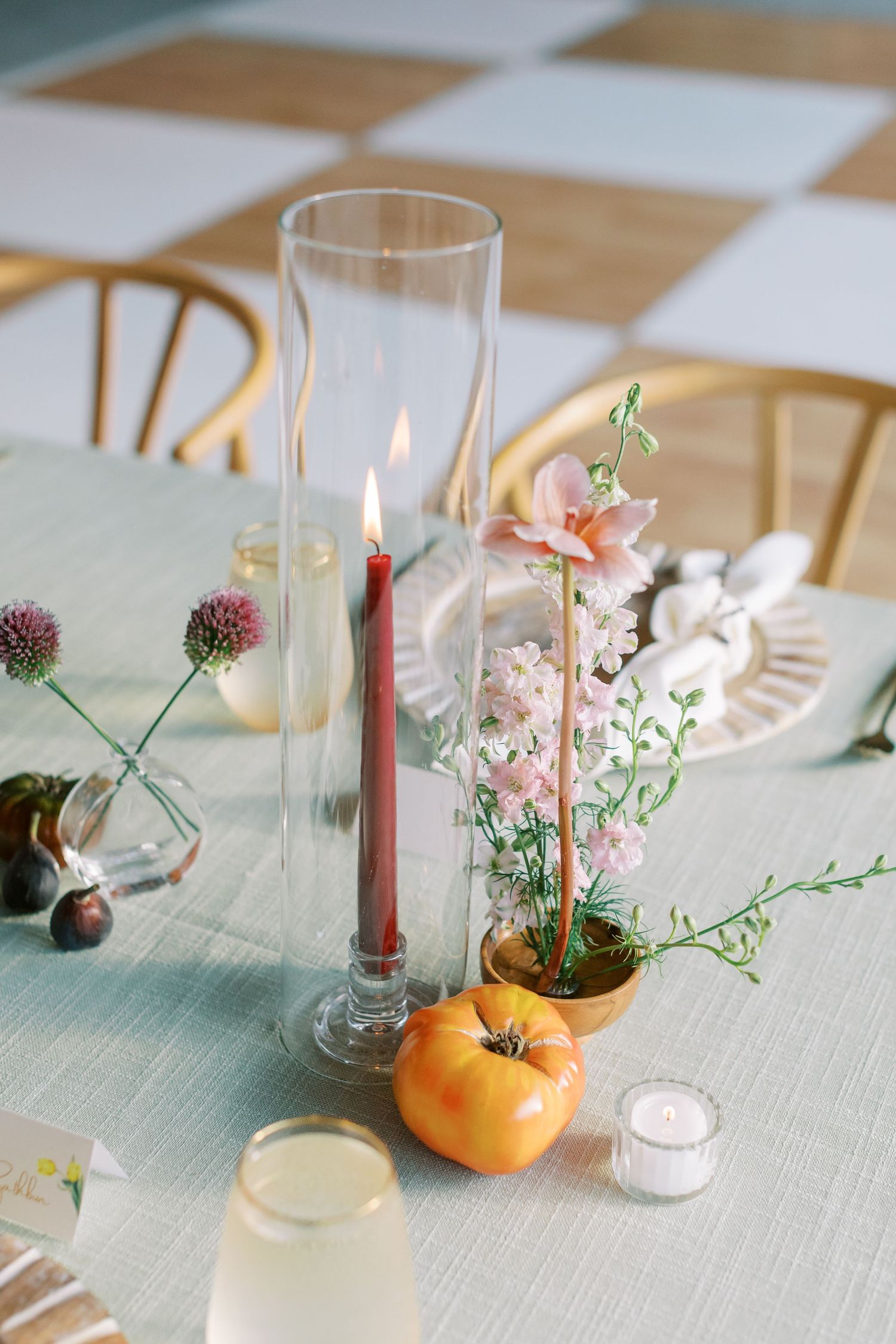 Elegant table centerpieces featuring delicate flowers in citrus fruits and glass vases.