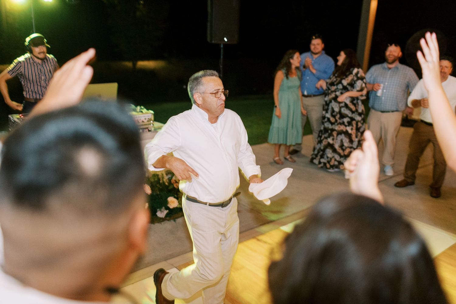 People dancing and enjoying themselves at a lively outdoor evening celebration event.