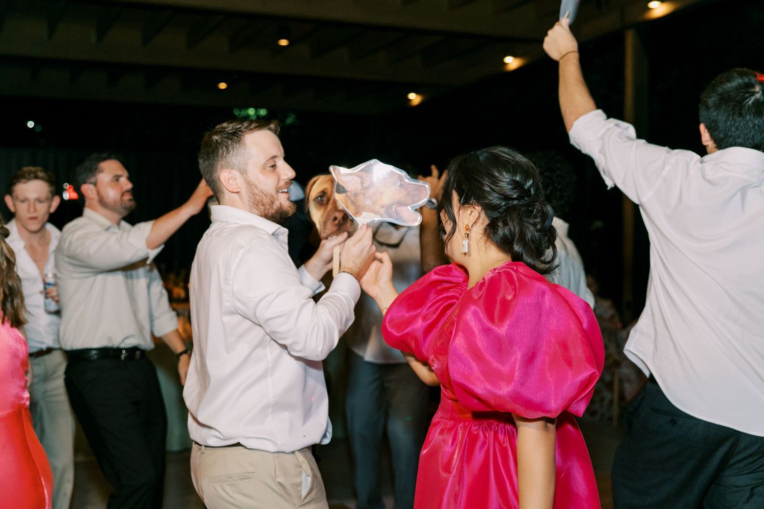 Wedding guests dancing and celebrating during an evening reception party.