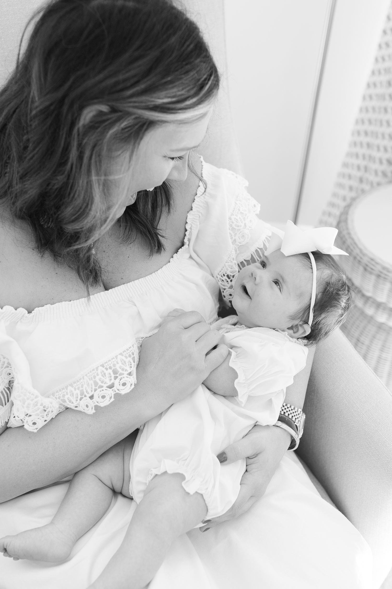Black and white portrait of a tender mother-baby moment in white lace clothing.