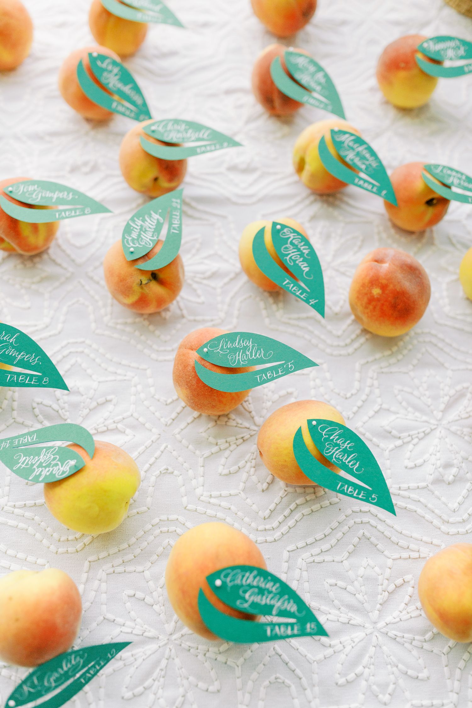 Fresh peaches arranged with teal paper leaves as wedding favors.