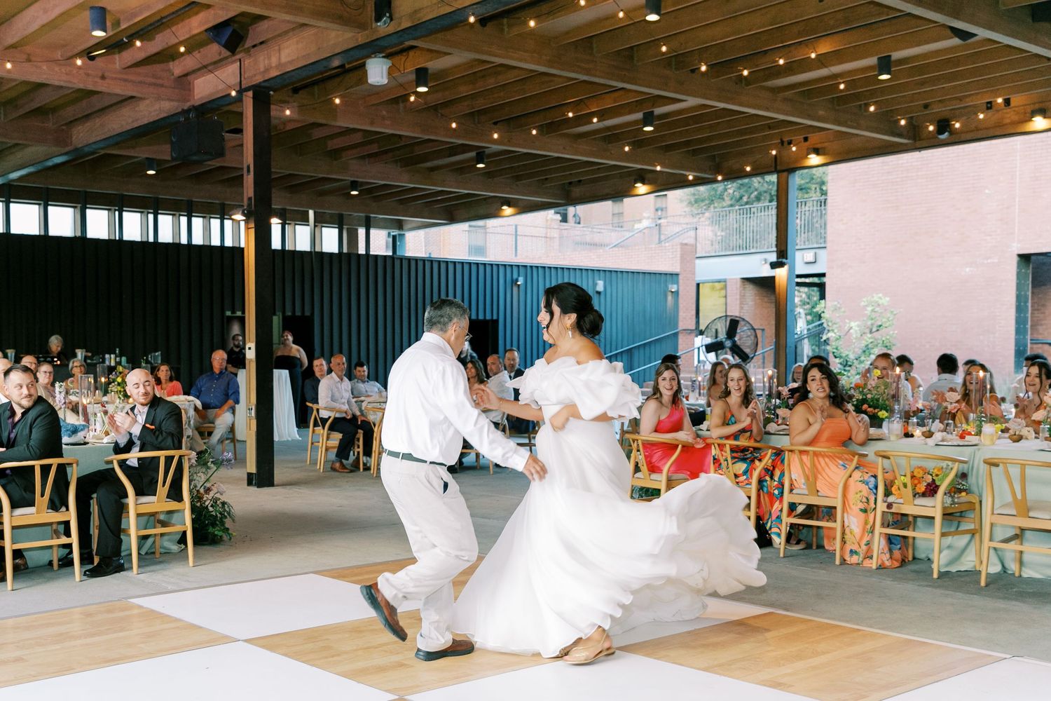 Couple performs their first dance at modern industrial wedding reception venue.