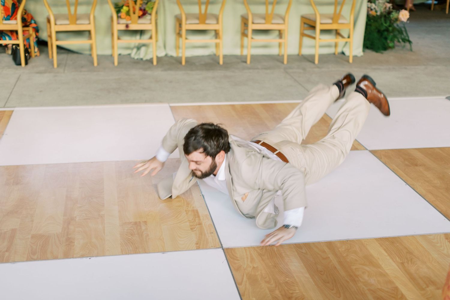 A playful moment captured on a checkered dance floor at a wedding reception.