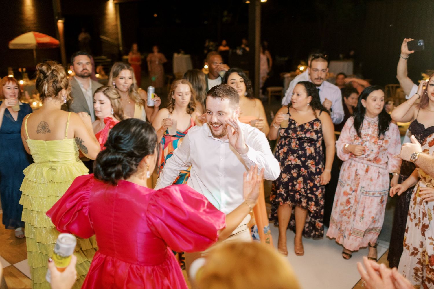 Wedding guests dance enthusiastically during lively reception party.