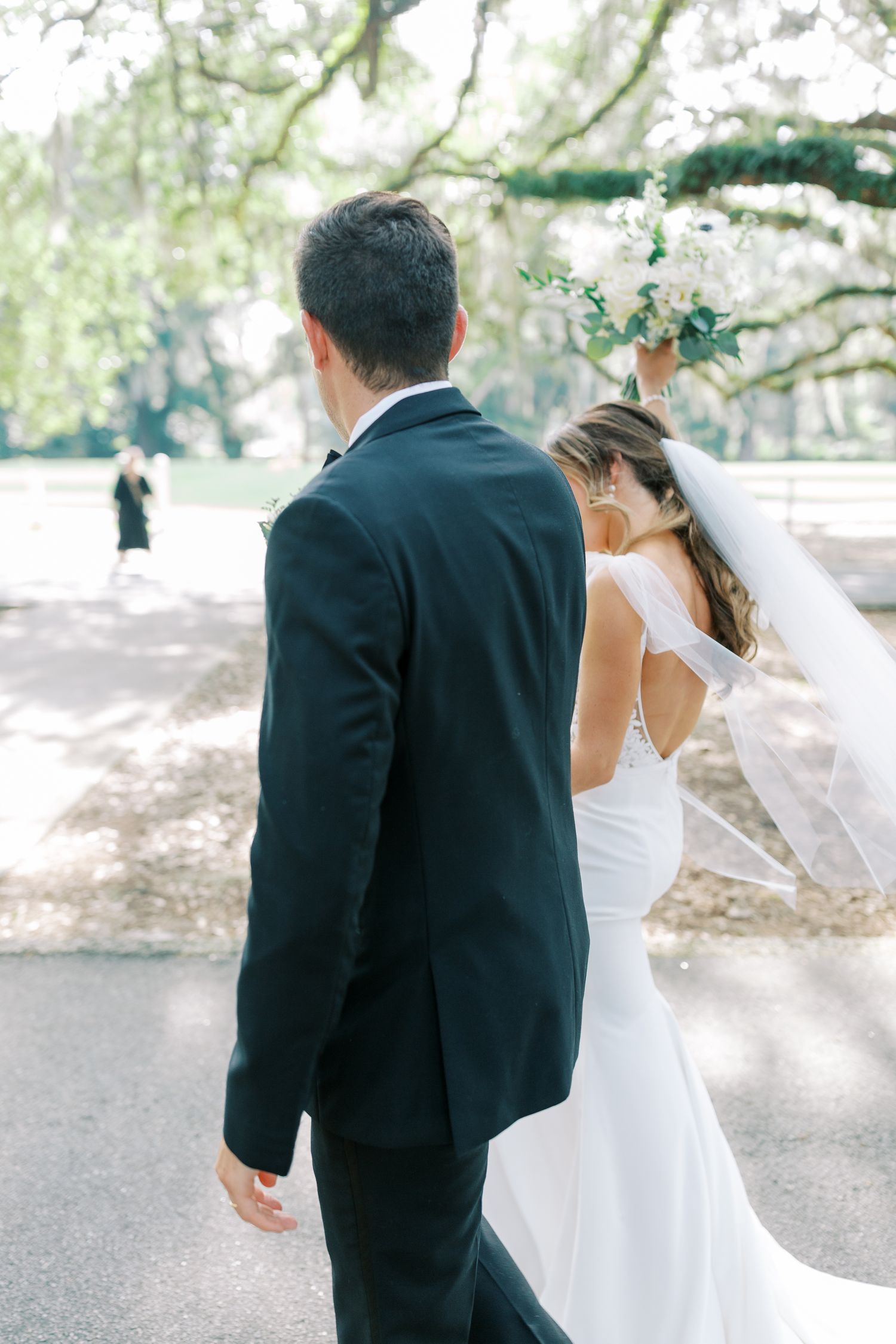 Bride celebrates after just being married under Spanish moss-draped trees with soft natural lighting.