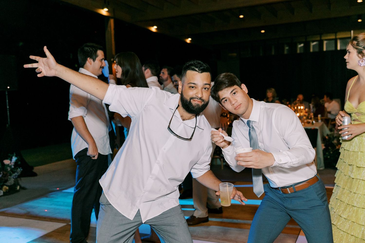 Lively dance floor scene at nighttime wedding reception with guests celebrating.
