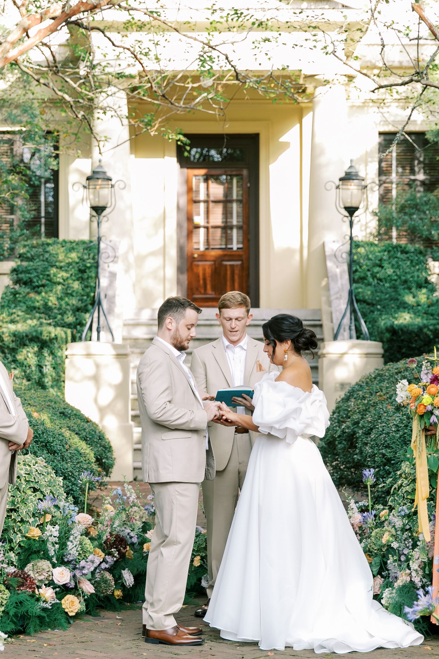 Intimate wedding ceremony moment on stone steps with lanterns and floral garden decor.