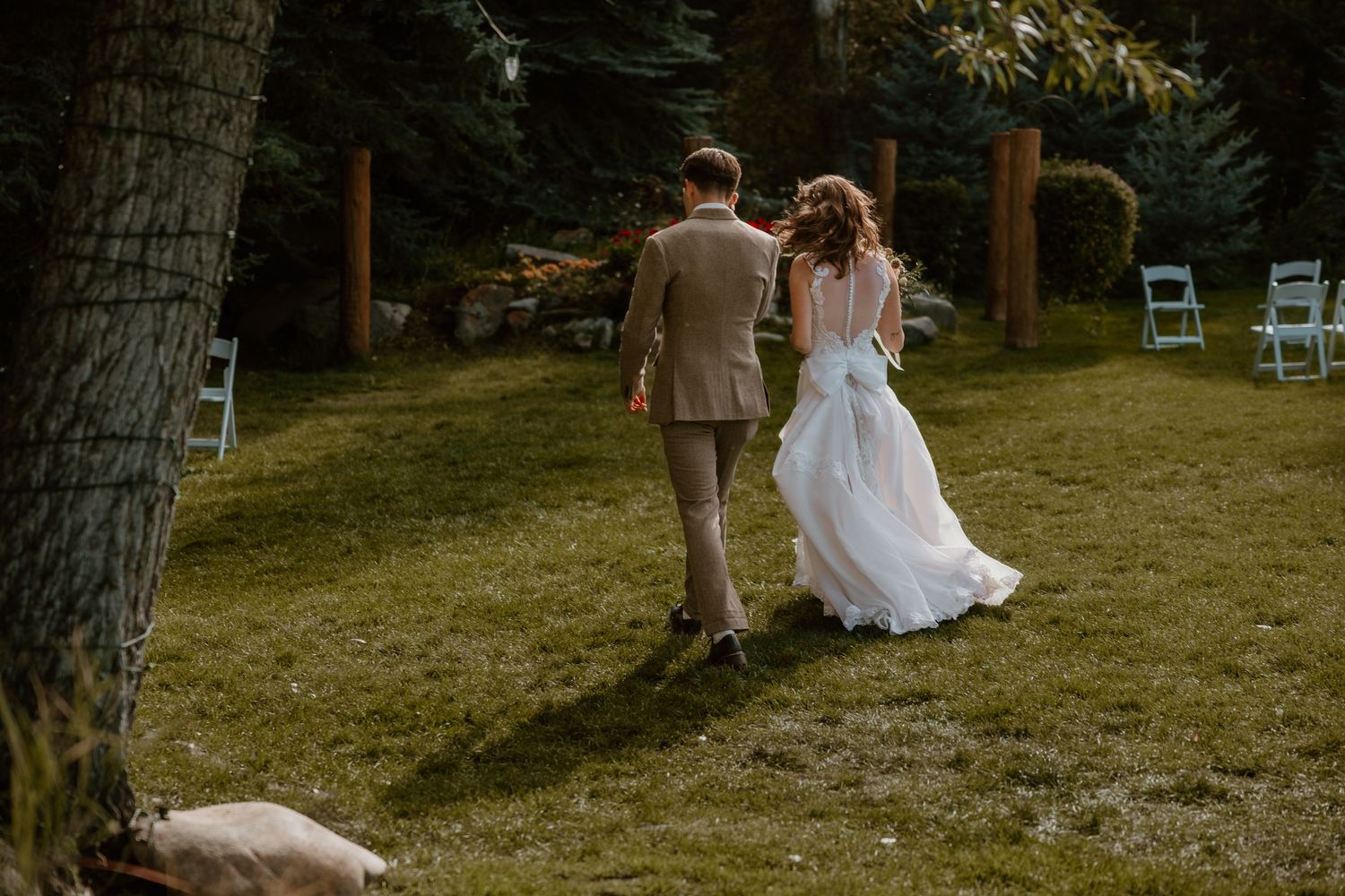 Garden wedding ceremony setup with chairs and trees in natural lighting.
