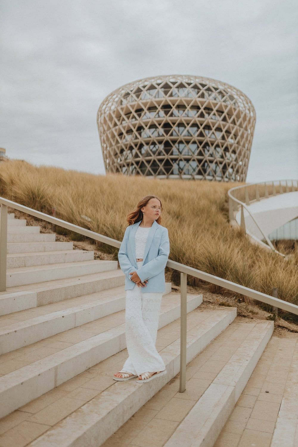 Een communiekant in witte broek en blauwe blazer staat op de trappen voor het casino hotel van Middelkerke.
