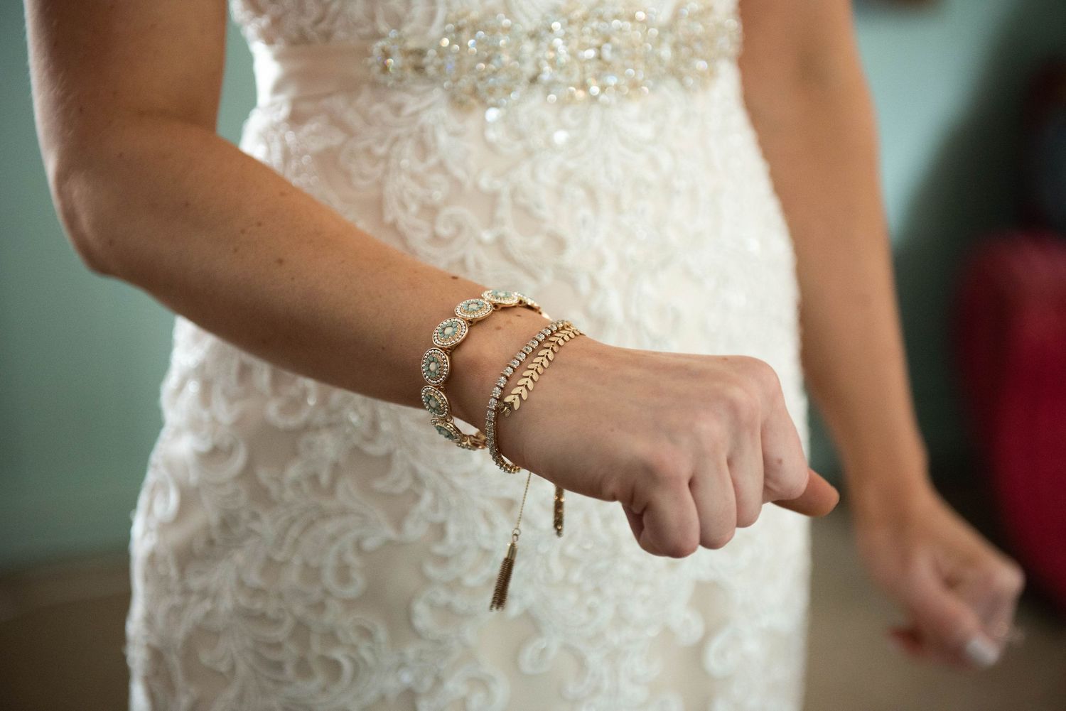 Close-up of a bride's wrist wearing an elegant crystal bracelet with her white lace dress. Rum River Barn Milaca Minnesota Weddings