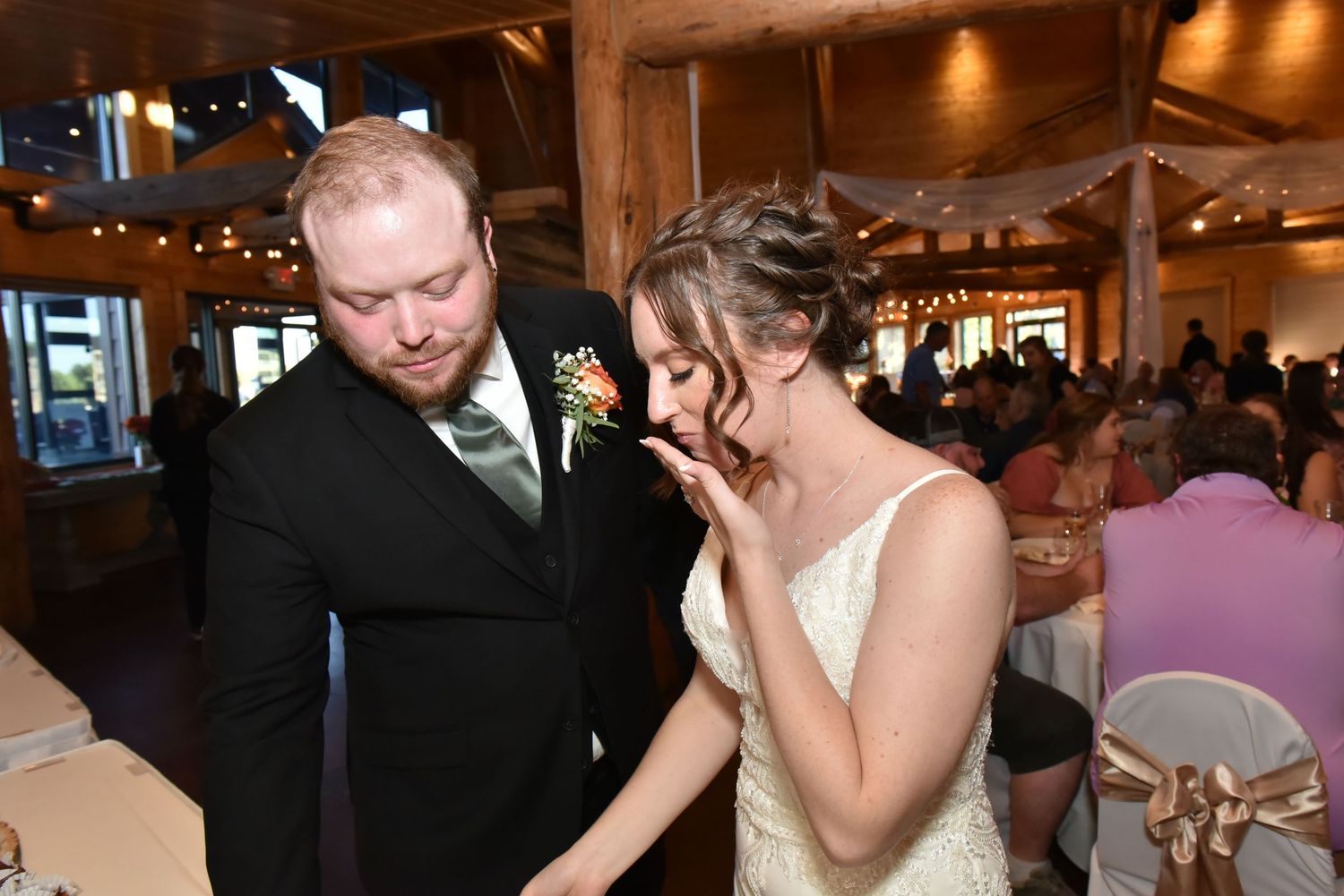 Emotional moment between couple during first dance at dimly lit wedding reception.