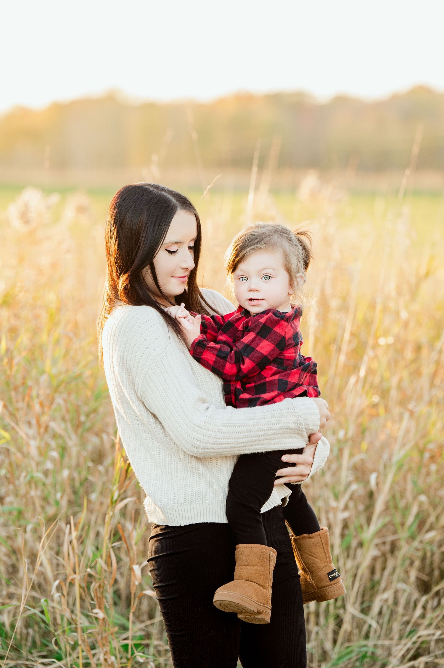 Mother and child share a tender moment in a golden wheat field at sunset while wearing cozy fall attire. Princeton MN Milestone, Maternity a