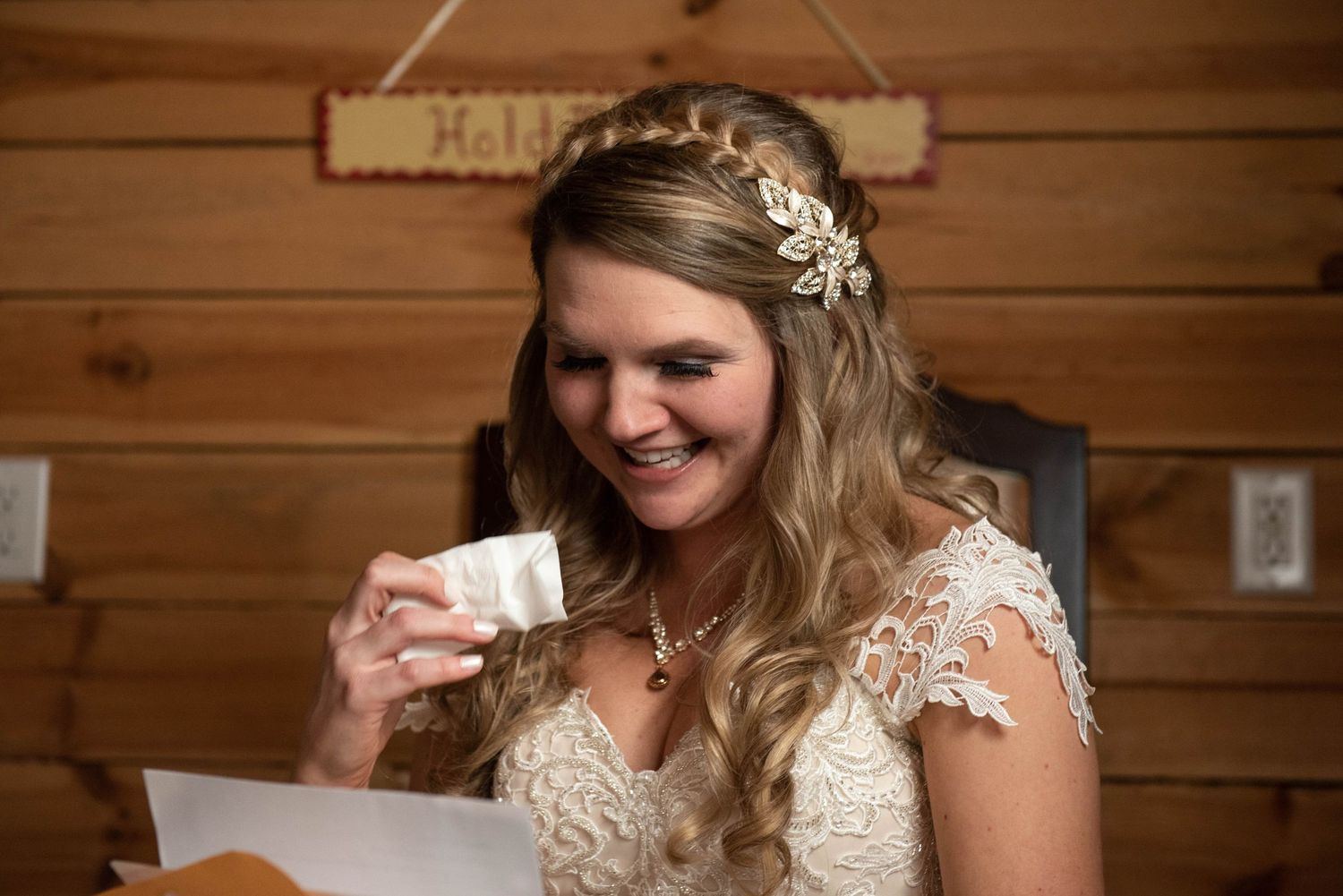 An emotional moment captured as someone in a wedding gown reads a heartfelt letter. Rum River Barn Milaca Minnesota Weddings