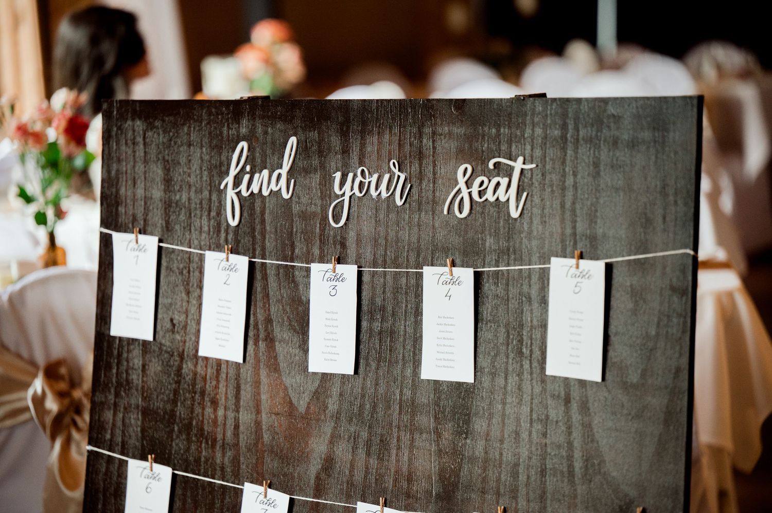 The Grands at Mulligans- Wedding Photos: A rustic wooden seating chart display with 'find your seat' text and hanging cards.