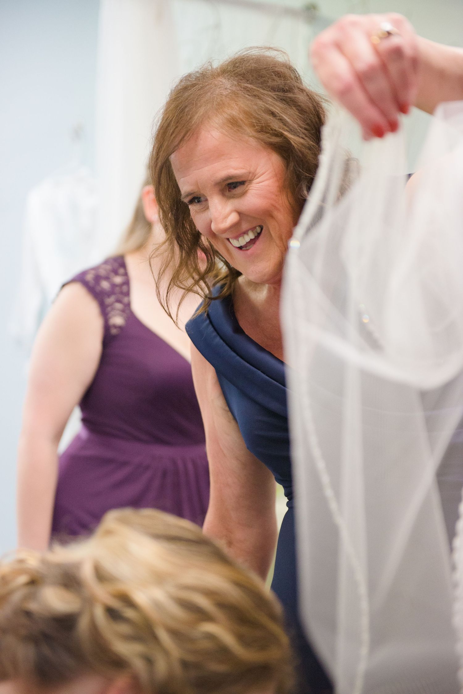 Candid moment of laughter and joy during a wedding dress fitting appointment. Andover wedding at Magestic Oaks Golf Club