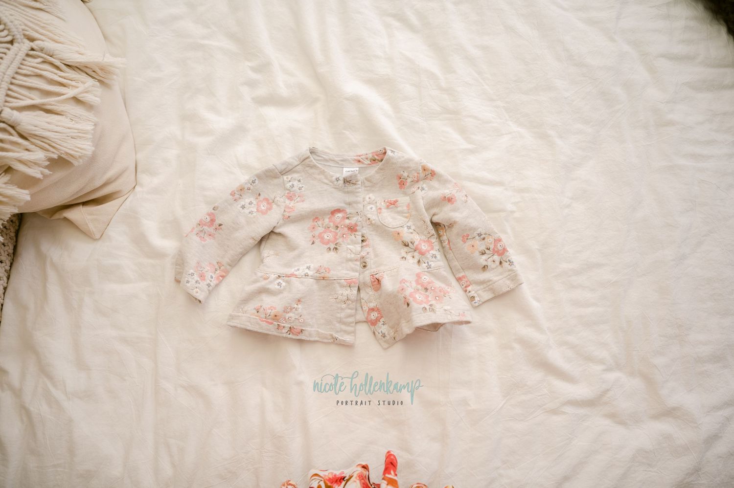 A delicate floral pattern on white fabric creates a soft, feminine ruffle detail against a cream-colored background.