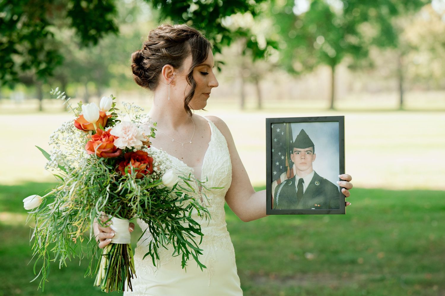 Wedding couple taken in sunny outdoor setting with willow trees and rustic natural bouquet.