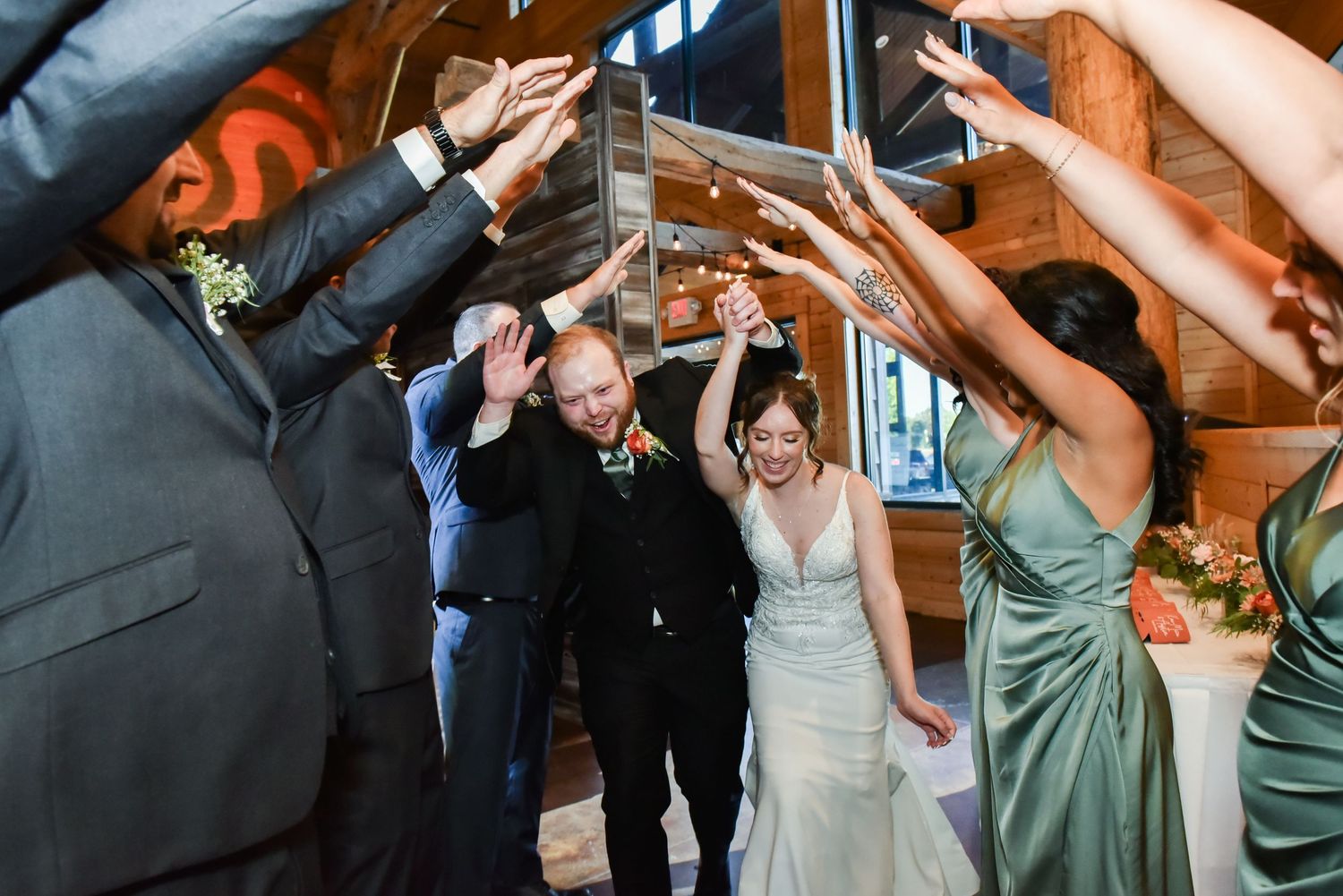 The Grands at Mulligans- Wedding Photos: Wedding party dancing and celebrating beneath string lights at indoor reception.