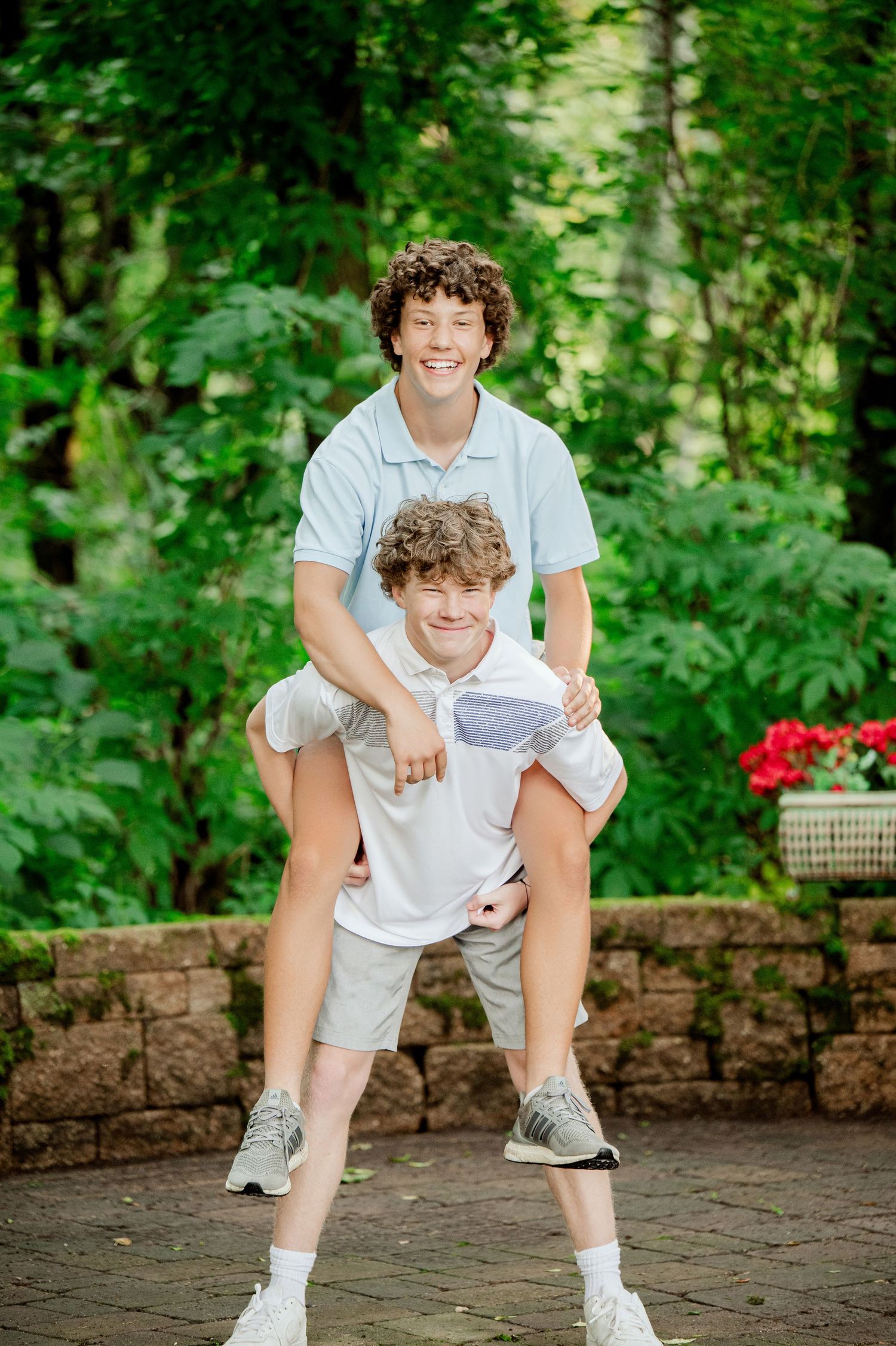 Clear Lake MN Family Photos: Candid photography series showing joyful interactions on a stone patio surrounded by greenery.