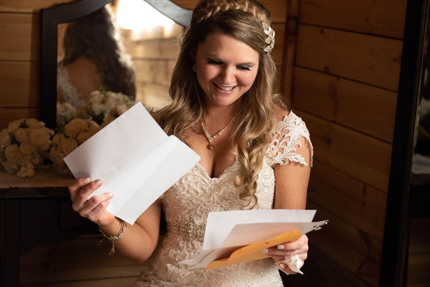 Someone reading emotional letters during wedding day preparations in rustic wood-paneled room. Rum River Barn Milaca Minnesota Weddings