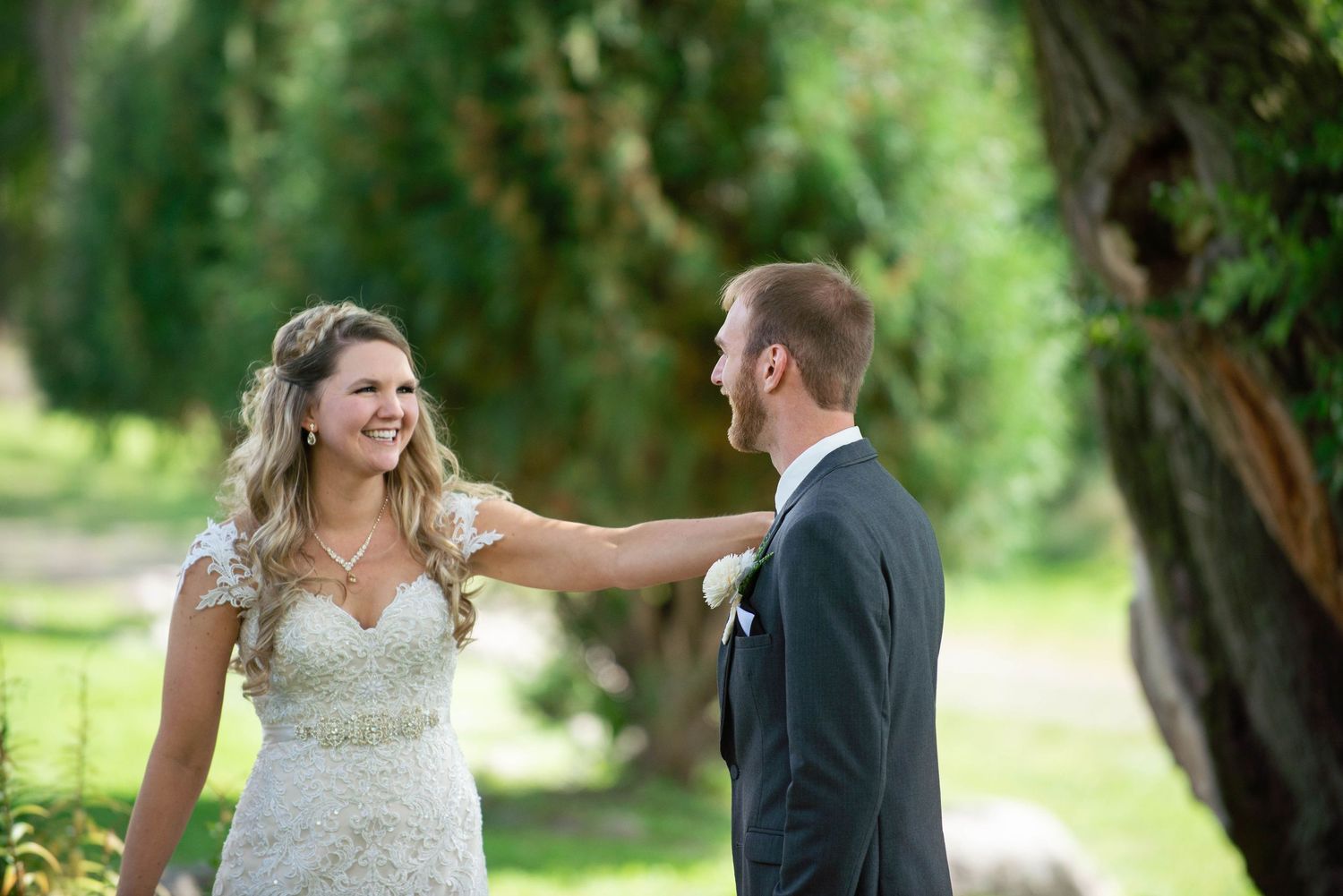 Newlyweds share joyful moment together in garden setting during outdoor wedding photoshoot. Rum River Barn Milaca Minnesota Weddings